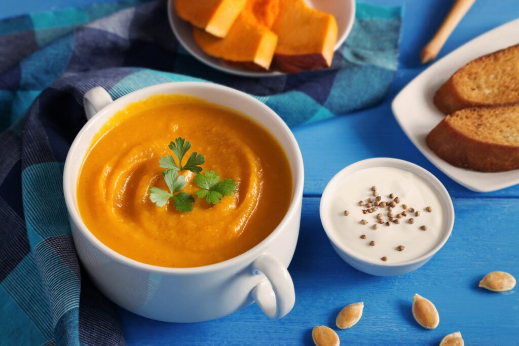 bowl of carrot soup on a blue tablecloth