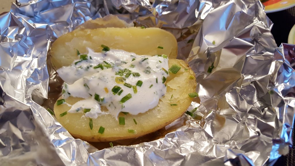 baked potato in foil with a creamy dressing