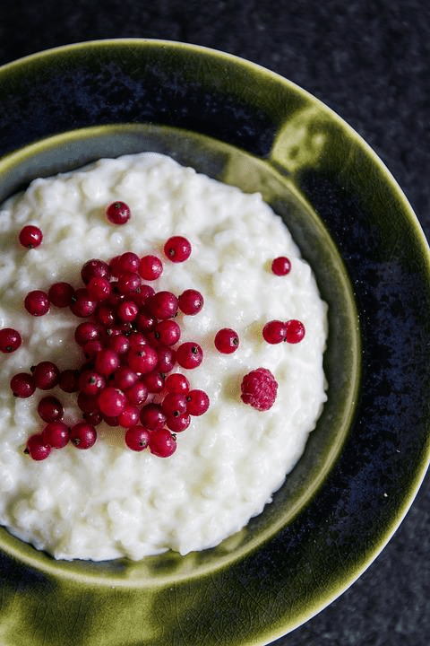 sticky rice with red berries on tip in a green bowl