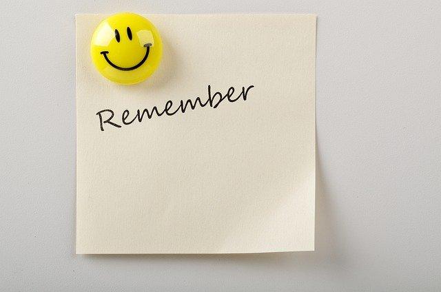 A "remember" note attached to a wall with a smiley face magnet