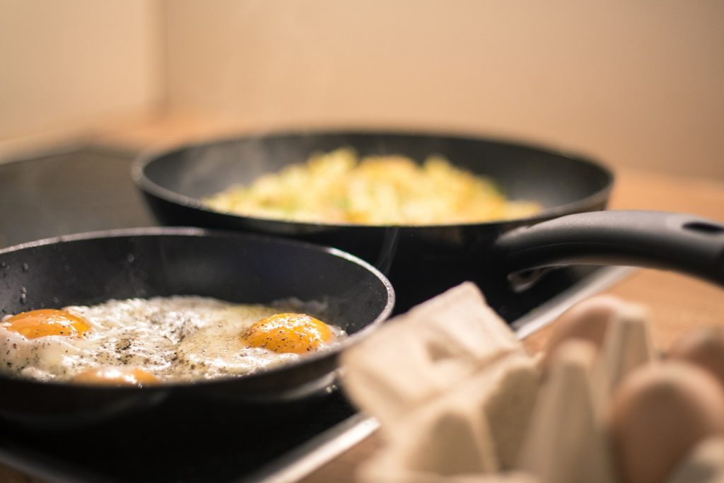 cooking fried eggs in a round frying pan