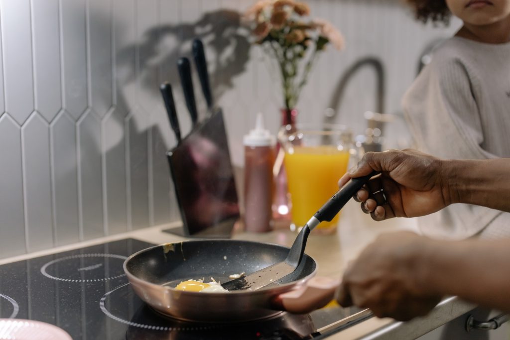 cooking a fried egg in a frying pan on an induction hob