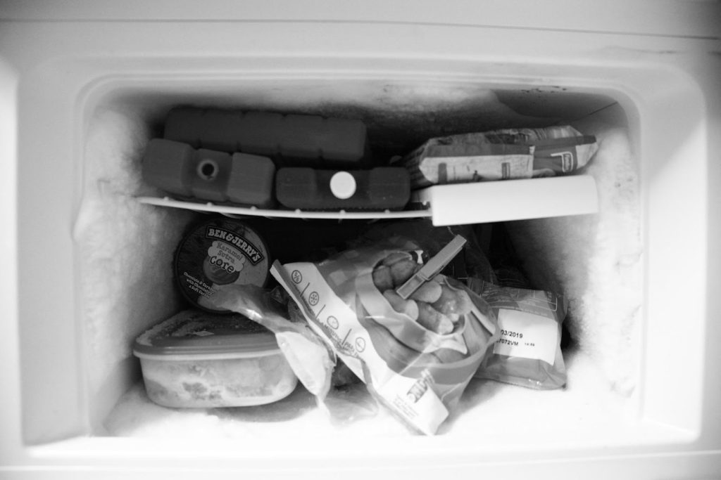 ice build up in an old style fridge freezer with packaged food wedged tight