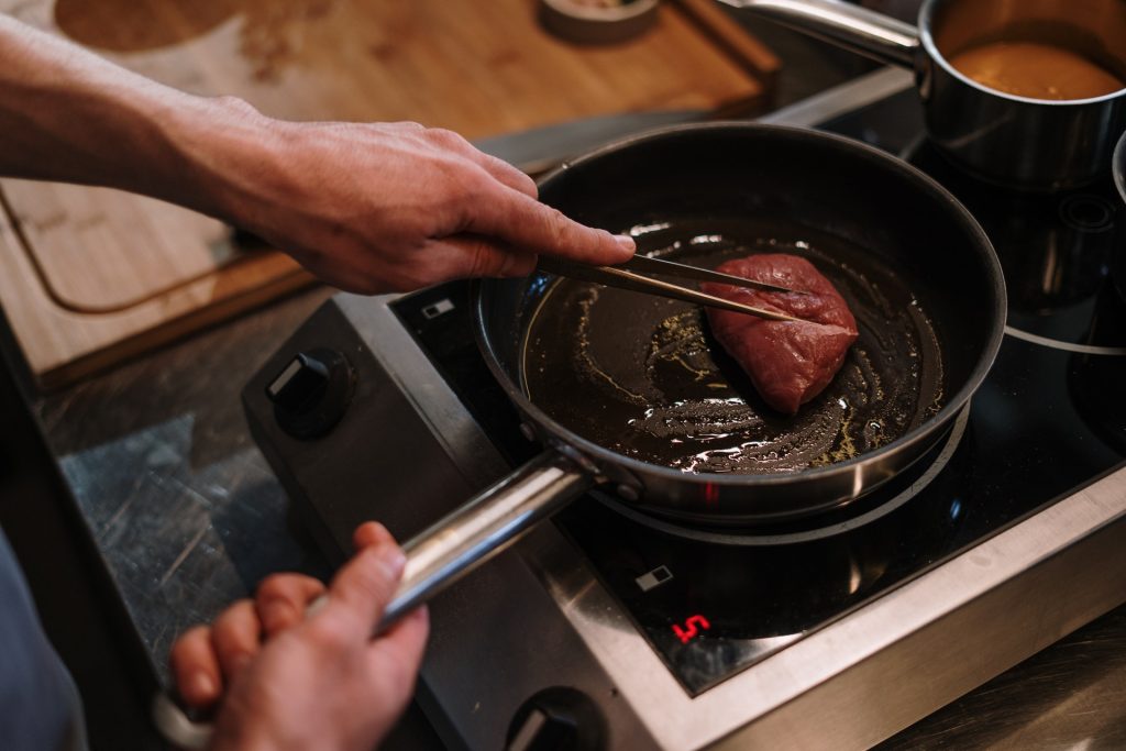 cooking steak in a frying pan 