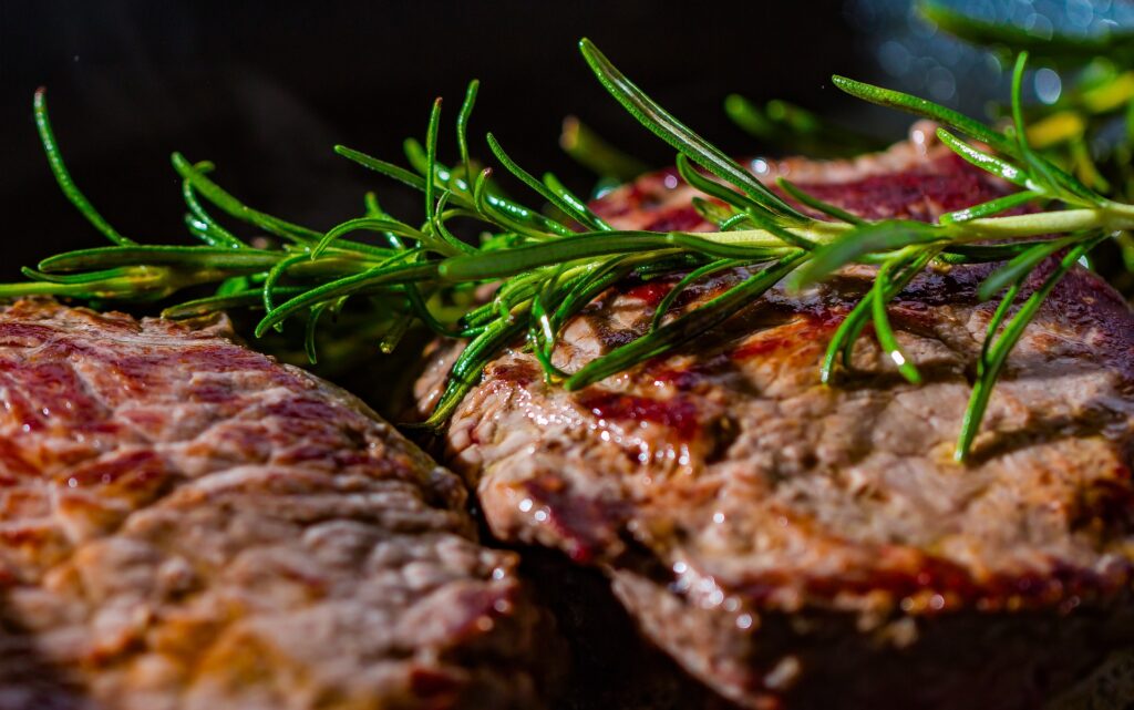 cooked steak with a sprig of rosemary