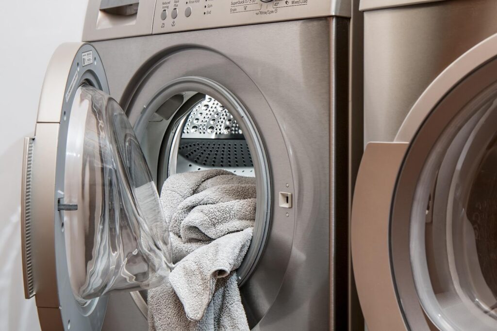 tumble dryer with door open and dry towels tumbling out