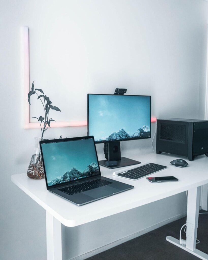 laptop and monitor on a white desk
