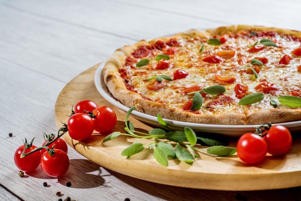 simple pizza on a plate garnished with herbs and cherry tomatoes