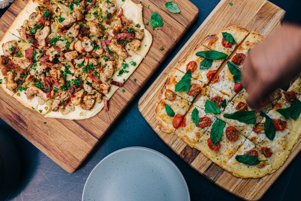 2 pizzas on wooden chopping boards